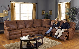 man and woman sitting on recliner sofa in room HD wallpaper